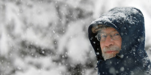 Man walking through snowstorm with a serious expression